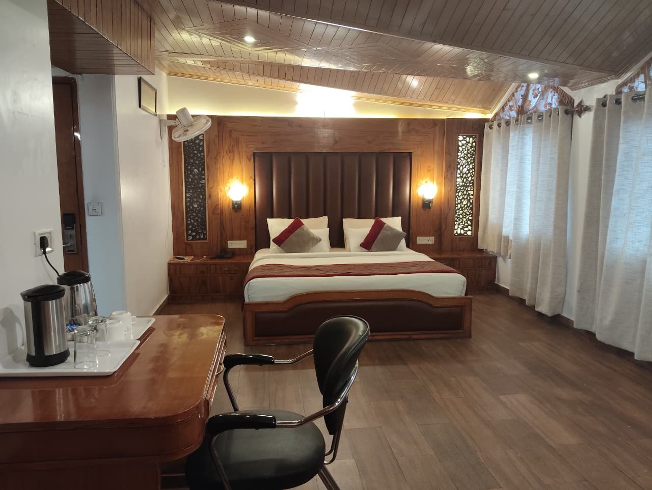 Spacious luxury suite room at Hotel Surya near Mall Road Shimla featuring a king-size bed, wooden interiors, work desk, seating area, and modern amenities for a premium stay.