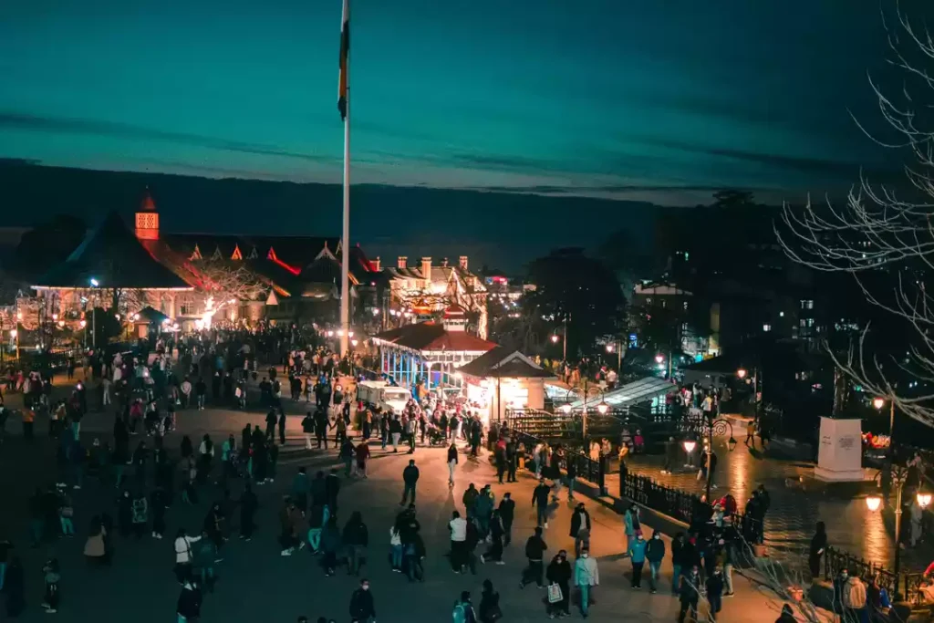 Evening view of Mall Road Shimla with illuminated shops and tourists exploring the market